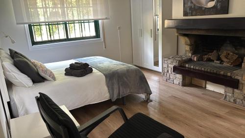 a bedroom with a bed with a fireplace and a chair at Loft anexo en chalet, con piscina de uso privado in San Juan