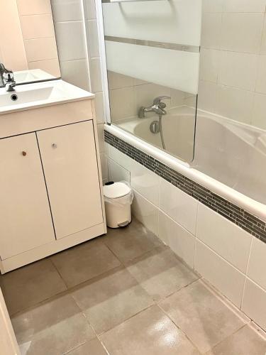 une salle de bain avec un lavabo, une baignoire et une douche dans l'établissement L'escapade sur l'île Saint Laurent, à Chalon-sur-Saône