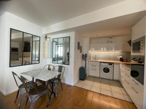 une cuisine avec une table et des chaises dans une pièce dans l'établissement L'escapade sur l'île Saint Laurent, à Chalon-sur-Saône