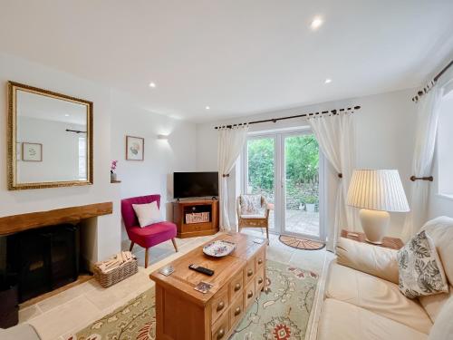 a living room with a couch and a fireplace at Copper Cottage in Atworth