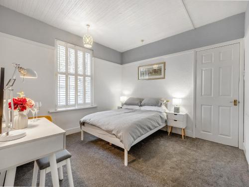 a bedroom with a bed and a desk and a window at Cherry Blossom in Skegness