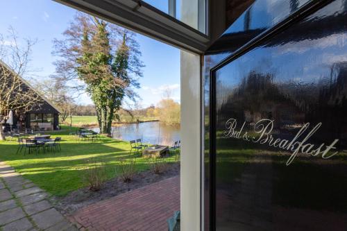 a window of a building with a view of a lake at Malle Mühle Bed & Breakfast in Lage