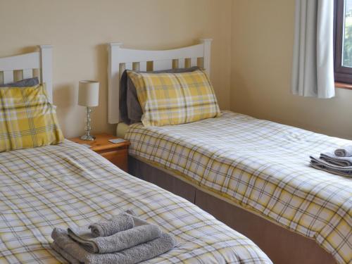 a bedroom with two beds with towels on them at The Junipers in Tain