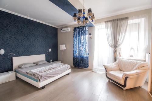 a bedroom with a bed and a couch and a chair at Family Apartments on Galaktionova in Kazan