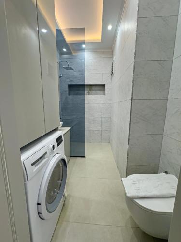 a bathroom with a washing machine and a toilet at İnci suites & Tatil Evleri in Alanya