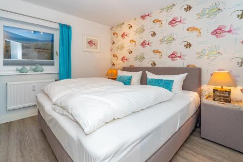 a bedroom with a large white bed in a room at Söl'ring Hüs "Rantumer Idyll" in Rantum