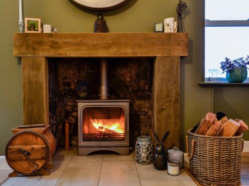 a fireplace with a fire in it in a room at Cotlea East Cottage in Alyth