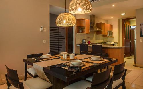 a kitchen and dining room with a table and chairs at Departamento Mayan Lakes T6 - Albercas, club de playa, tenis, pádel y más in Acapulco