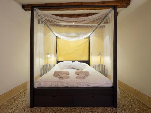 a bedroom with a canopy bed with two towels on it at Casa Margherita in Venice