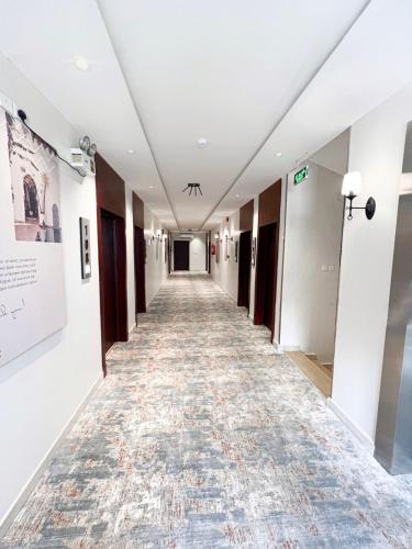 an empty hallway in a building with a rug on the floor at شقق دور وارف للشقق المخدومة Dor WAREF FOR SERVICED APARTME in Al Kharj