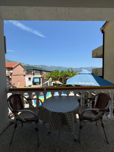 a table and chairs on a balcony with an umbrella at ROOM 03 Villa KRIVOKAPIC in Budva