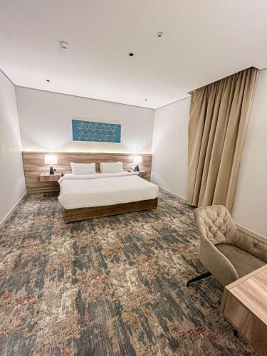 a hotel room with a bed and a chair at شقق دور وارف للشقق المخدومة Dor WAREF FOR SERVICED APARTME in Al Kharj