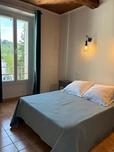une chambre avec un lit et une grande fenêtre dans l'établissement Les Allée, à Riez