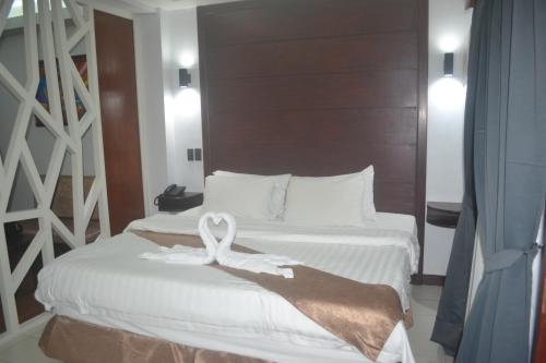 a hotel room with two beds with towels on them at DM Residente Hotel Inns & Villas in Angeles