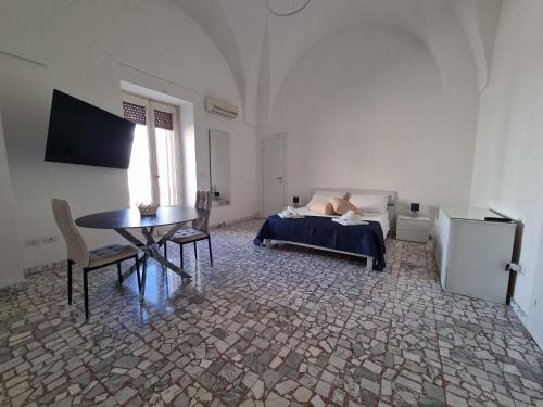 a bedroom with a bed and a table and a desk at Templari Suite in Mesagne