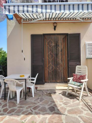 eine Terrasse mit Tisch und Stühlen vor einem Haus in der Unterkunft Casa di Caterina in Castiglioncello