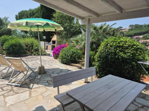a table and chairs and an umbrella on a patio at Rosa dei Venti Est in Capoliveri