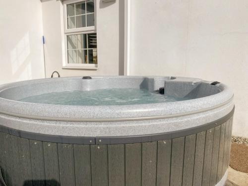 une baignoire jacuzzi dans une chambre avec fenêtre dans l'établissement Fir Cottage - Uk38485, à Saltash