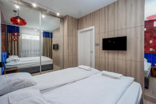a bedroom with two beds and a tv on a wall at Art Box - Gdańska Brzeźno in Gdańsk