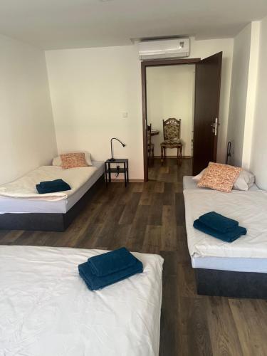 a room with three beds and a table and a chair at Vinný sklípek Drápalík in Milovice