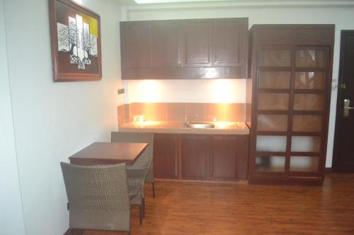 a kitchen with a sink and a table with chairs at DM Residente Hotel Inns & Villas in Angeles