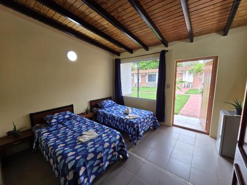 a bedroom with two beds and a large window at Posada La Luz del Caribe in La Mira