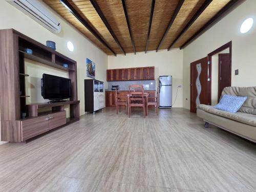 a living room with a couch and a tv and a kitchen at Posada La Luz del Caribe in La Mira