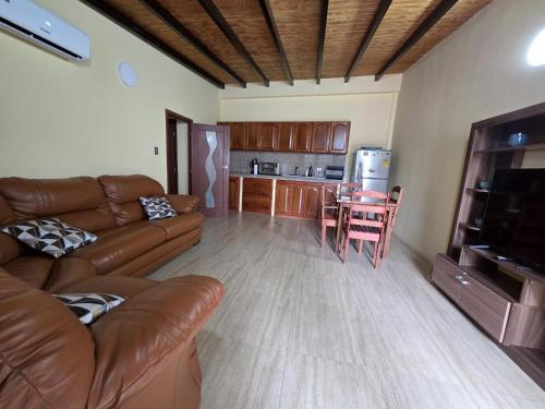 a living room with a couch and a table and a kitchen at Posada La Luz del Caribe in La Mira