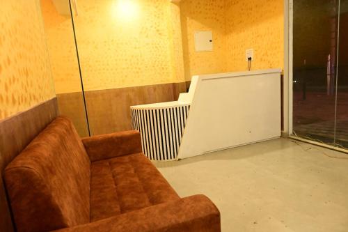 a living room with a couch and a radiator at Hotel Amar in Belagula
