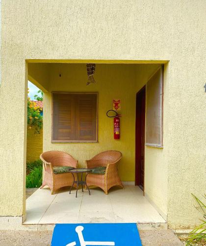 a patio with a table and two chairs in a building at Pousada e Chalés Recantos do Mar in Barra Grande