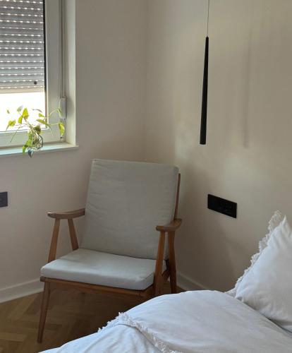 a chair sitting next to a bed in a bedroom at Riverside Luxury Apartment in Štip
