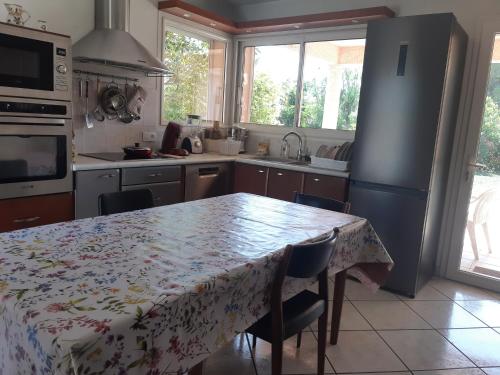 eine Küche mit einem Tisch mit einer Tischdecke darauf in der Unterkunft Villa de standing avec gd jardin arboré près d'Argelès sur Mer in Saint-André