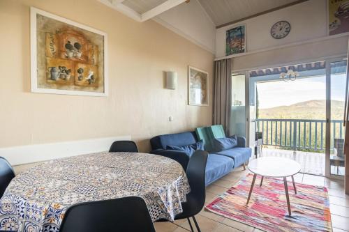 salon z niebieską kanapą i stołem w obiekcie Les Appartements aux Restanques du Golfe de St Tropez - maeva Home - Appartement avec mezzanine 2 Pièces 4 Personnes - Confort MAE-3700 w mieście Grimaud