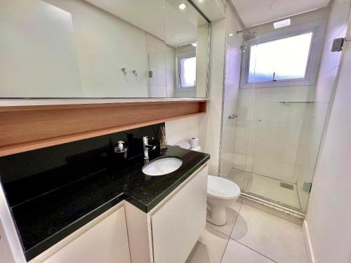 a bathroom with a sink and a toilet and a shower at Urban Apt 601 Comfortable and Complete in Caxias do Sul