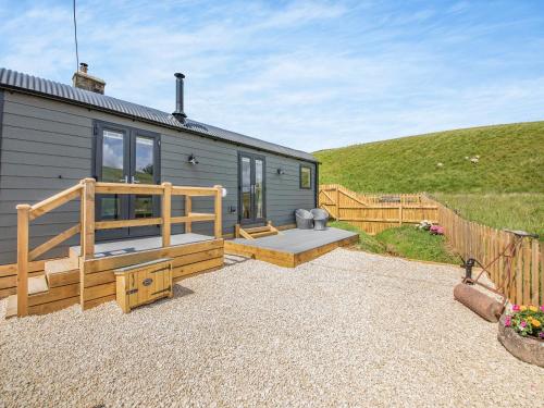 a tiny house with a porch and a patio at The Liddel Dutch Barn - Uk44465 in Saughtree