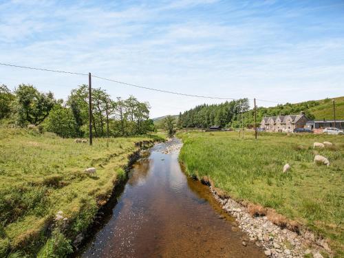 a river in a field with sheep in the grass at The Liddel Dutch Barn - Uk44465 in Saughtree