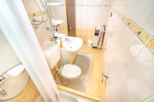 a bathroom with a toilet and a sink and a shower at Apartments Katarine Zrinske in Vodice
