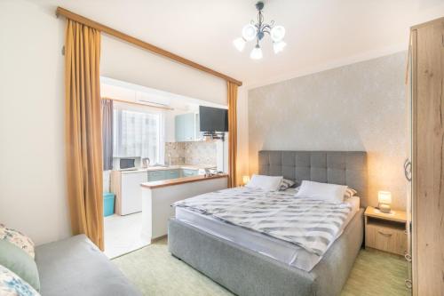 a bedroom with a bed and a small kitchen at Apartments Katarine Zrinske in Vodice