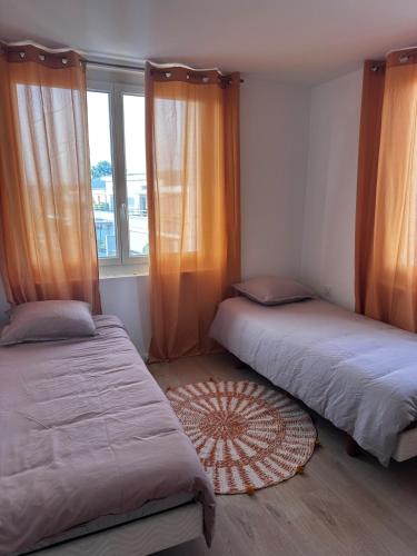 deux lits dans une chambre avec une fenêtre dans l'établissement La Parenthèse - Proche de la Gare - Parking, à Valence