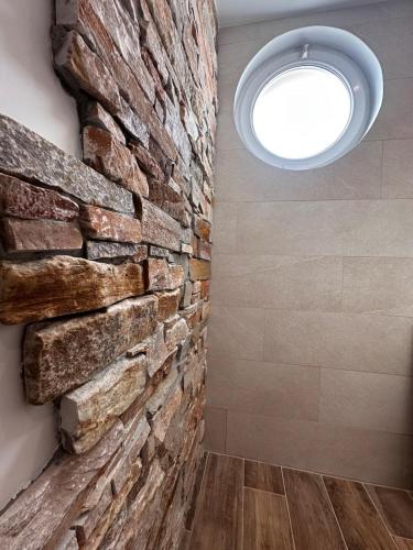 une pièce avec un mur en pierre et une fenêtre circulaire dans l'établissement La Parenthèse - Proche de la Gare - Parking, à Valence