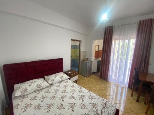 a bedroom with a bed and a table and a mirror at Vila Tani in Ksamil