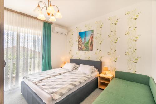 a bedroom with a bed and a couch and a window at Apartments Katarine Zrinske in Vodice