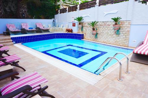 a swimming pool with purple chairs and a blue and white pool at Faros Suites (Adults Only) in Fiskardho