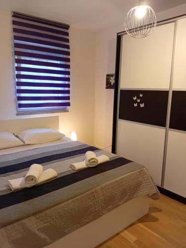 a bedroom with a bed with two towels on it at Apartman Anny in Široki Brijeg