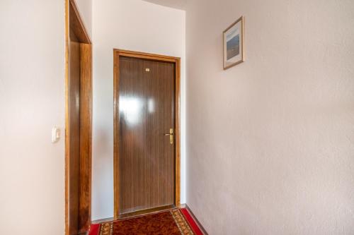 a hallway with a wooden door in a room at Apartments Katarine Zrinske in Vodice