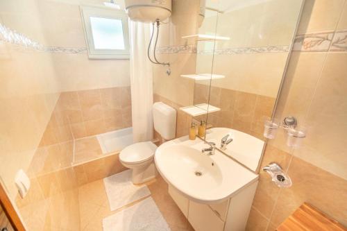a bathroom with a sink and a toilet and a shower at Apartments Katarine Zrinske in Vodice