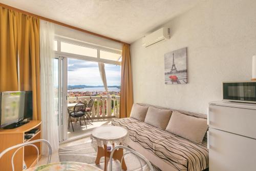 a living room with a couch and a balcony at Apartments Katarine Zrinske in Vodice