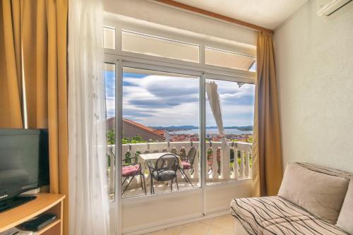 a room with a view of a balcony with a television at Apartments Katarine Zrinske in Vodice