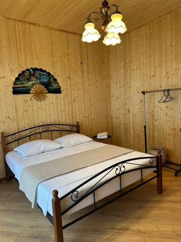 a bedroom with a bed and a chandelier at Dream House borjomi sadgeri in Sadgeri