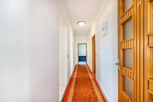 a hallway with a door and a rug at Apartments Katarine Zrinske in Vodice